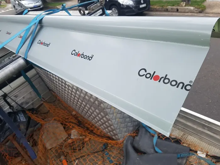 Roofing materials stacked beside a brick parapet on a Sydney job