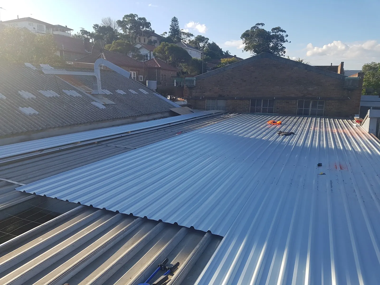 A newly sheeted metal roof beneath trees in Marrickville
