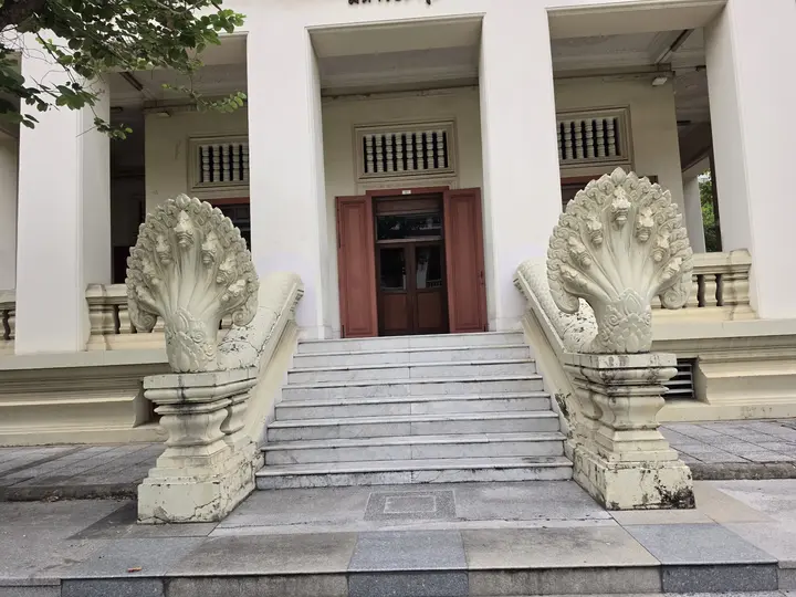 Naga statues guarding the steps of a white building