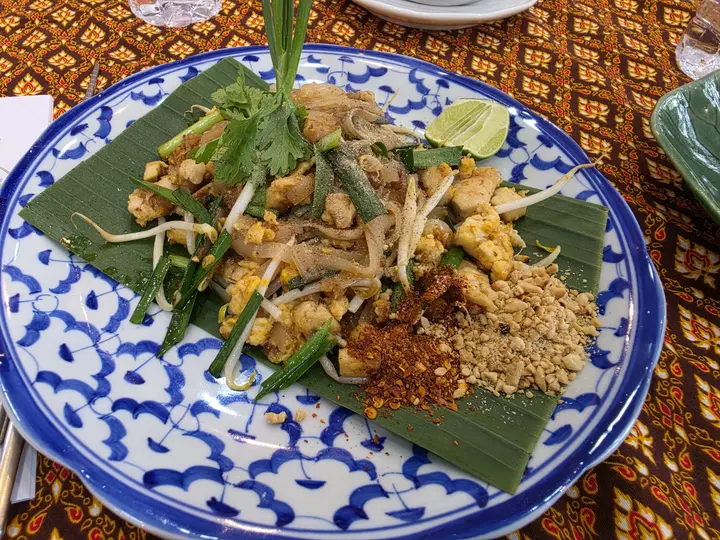 A plate of pad thai on a patterned tablecloth