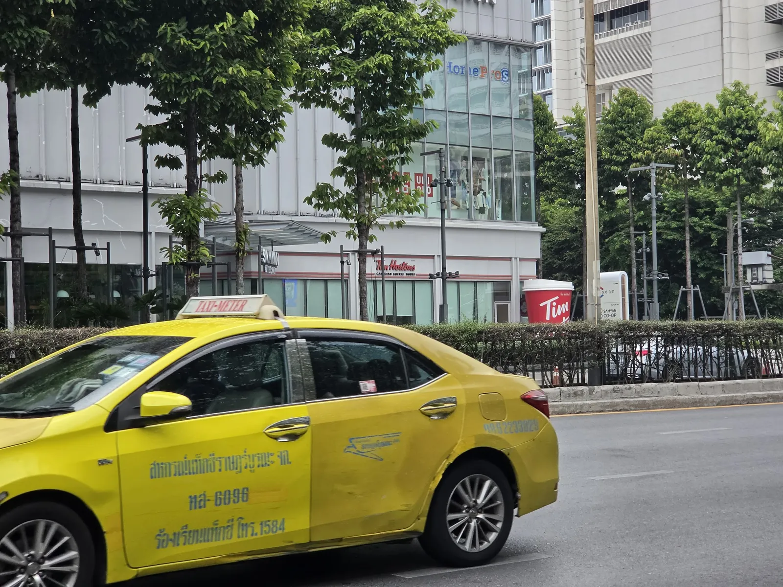 A yellow and green Bangkok taxi on Phaya Thai Road