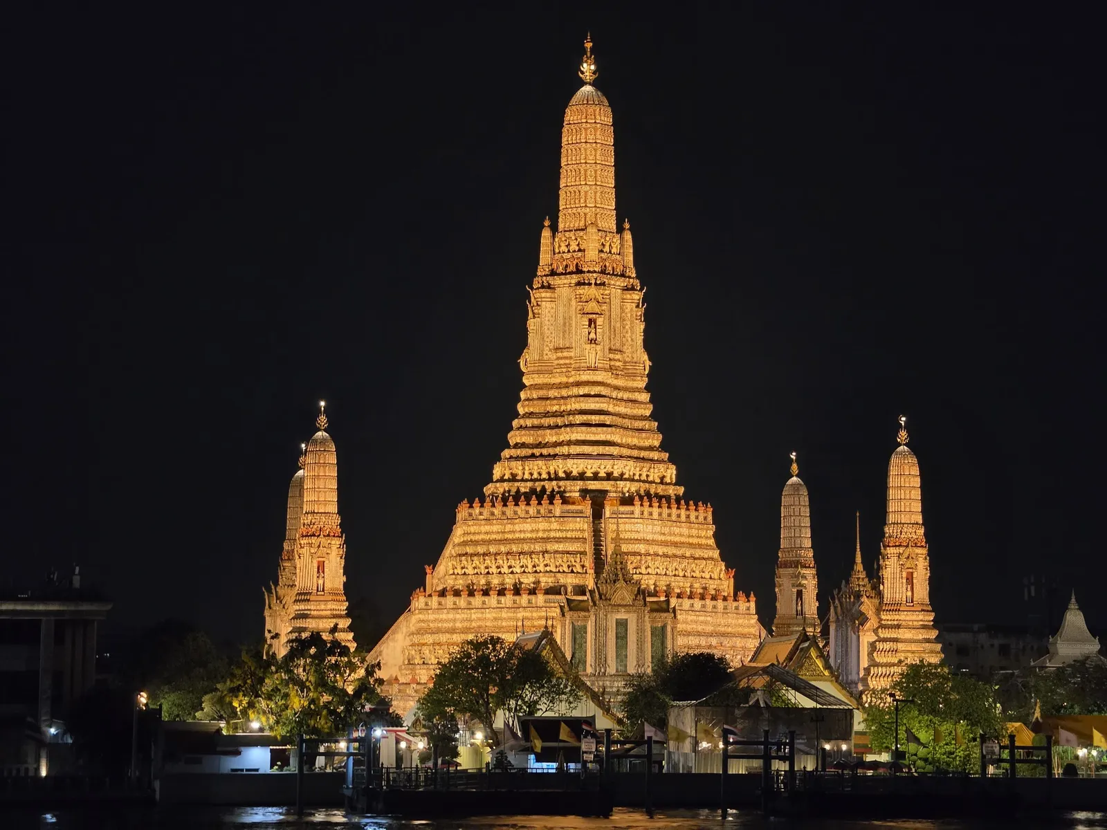 Wat Arun lit gold at night across the river