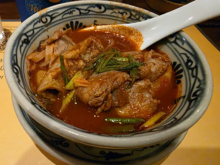 A bowl of noodle soup with herbs on a restaurant table in Da Nang