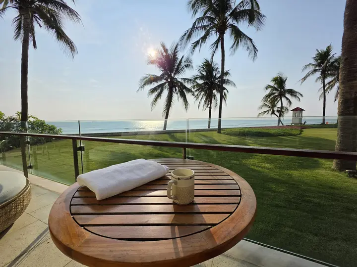 Palm trees and a towel on a table at the beach at 7 in the morning