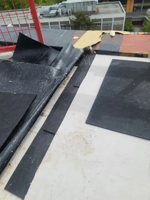 Membrane installation along a commercial rooftop.