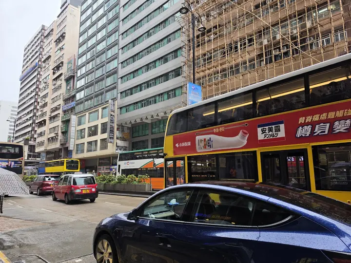 Red double-decker buses on a busy Kowloon street