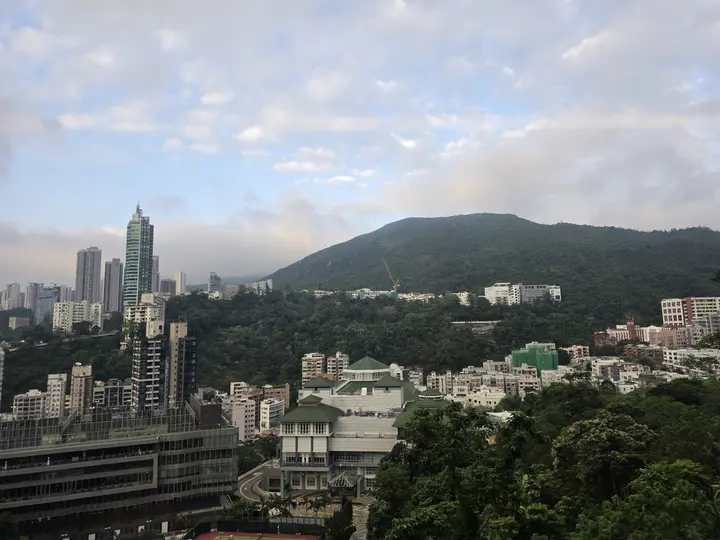 Green hills rising behind apartment blocks on Hong Kong Island