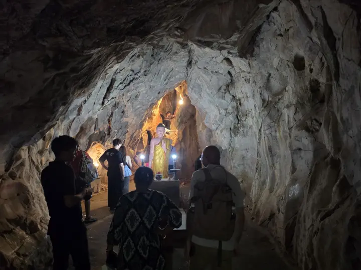 Visitors inside a lit cave in the Marble Mountains