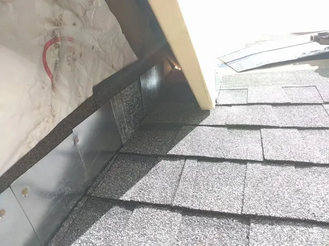 Roof flashing where a shingled slope meets the adjoining structure.