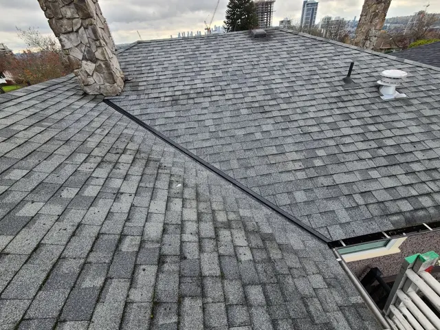 Grey shingle courses meeting at a roof valley.